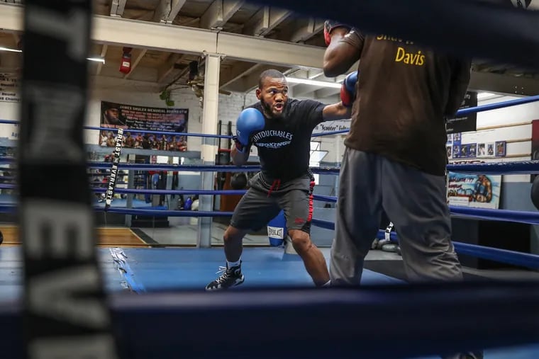 At the Shuler Memorial Boxing Gym in West Philadelphia, Julian Williams, center, who is the light-middleweight boxing champion, trains with Stephen Edwards. A West Philly street kid, he began boxing as a 12-year-old