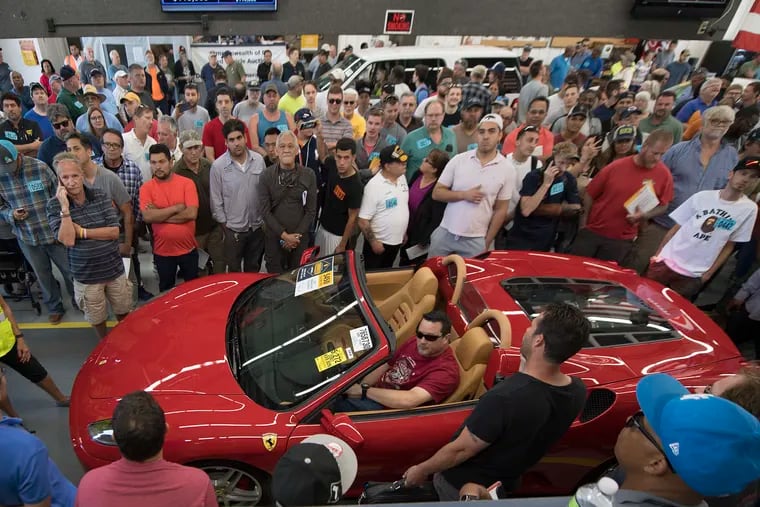 People gathered near a Ferrari auctioned for sale at the Manheim Auction in Grantville Pa. The luxury cars were seized during a drug case.Tuesday, June 12, 2018. JOSE F. MORENO / Staff Photographer