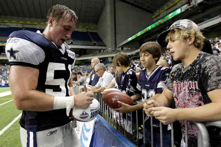 Cowboys linebacker Sean Lee signs a ball for a fan at training camp, where he had been slowed by injuries.