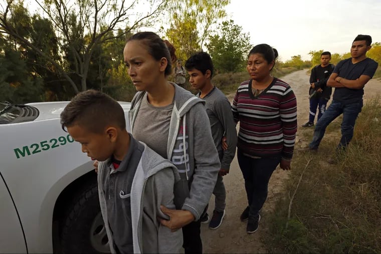 Migrants in McAllen, Texas, wait to be transported to a detention center earlier this year.