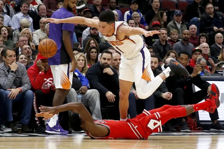 Devin Booker, here maintaining his dribble above the Bulls' Justin Holiday, leads the Suns.