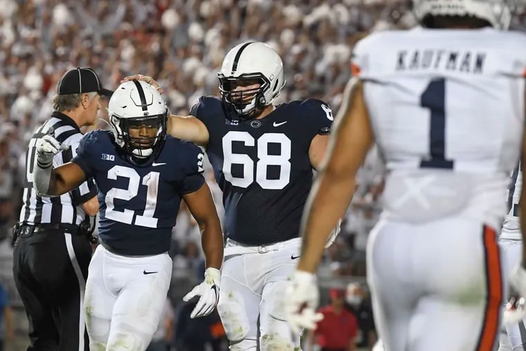 Penn State running back Noah Cain (21) celebrates with offensive lineman Eric Wilson after scoring a fourth-quarter touchdown against Auburn.