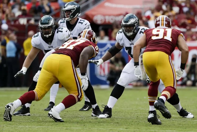 Eagles offensive tackle Halapoulivaati Vaitai and offensive guard Isaac Seumalo (left) block for quarterback Carson Wentz against Washington Redskins outside linebacker Ryan Kerrigan (right) and defensive tackle Terrell McClain during the third-quarter on Sunday, September 10, 2017, Landover, MD. YONG KIM / Staff Photographer