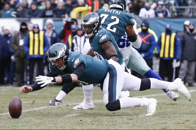 Eagles quarterback Nick Foles dives for the fumbled football with teammate Corey Clement during the first quarter against the Dallas Cowboys on Sunday.