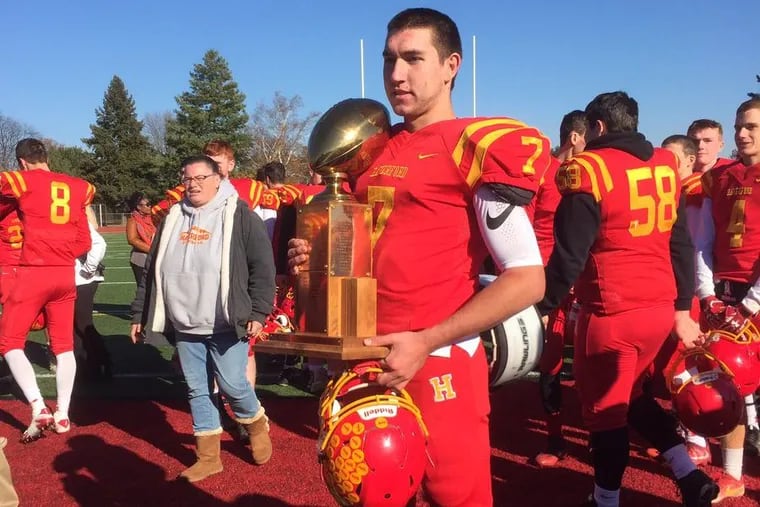 Haverford High quarterback Jake Ruane holds the trophy after his team beat Upper Darby, 14-7, on Thanksgiving Day.
