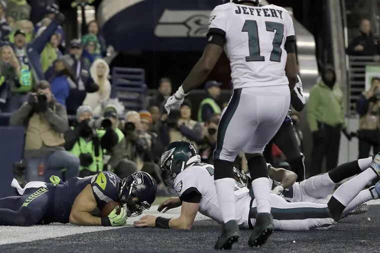 Seahawks’ Michael Wilhoite, left, is out of bounds as he falls on a fumble by Eagles’ Carson Wentz in the 3rd quarter. Philadelphia Eagles play the Seattle Seahawks in Seattle, WA on December 3, 2017. YONG KIM / Staff Photographer