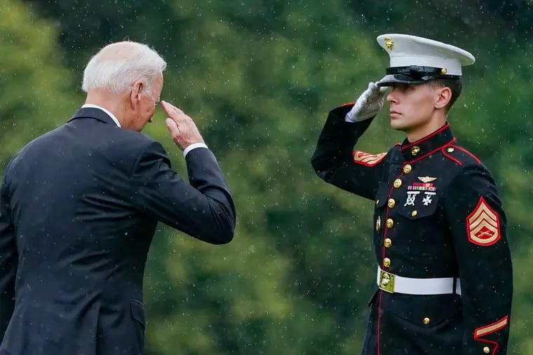President Joe Biden returns a salute as he walks to board Marine One at Fort Lesley J. McNair in Washington on Monday en route to Camp David after addressing the nation from the White House.