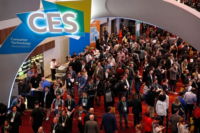 In this Jan. 9, 2018, file photo, people attend CES International in Las Vegas. The show went fully remote in January 2021 in the thick of the winter coronavirus surge, but is typically a sprawling in-person networking event. CES,  which will be held Jan 5-8, 2022, is struggling with a growing number of dropouts due to Omicron.  (AP Photo/John Locher, File)