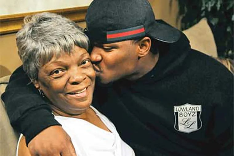 Curtis Brinkley, the city leagues’ all-time rushing leader, who was shot in July, kisses his grandmother, Margie Cason. (Sarah J. Glover / Staff Photographer)