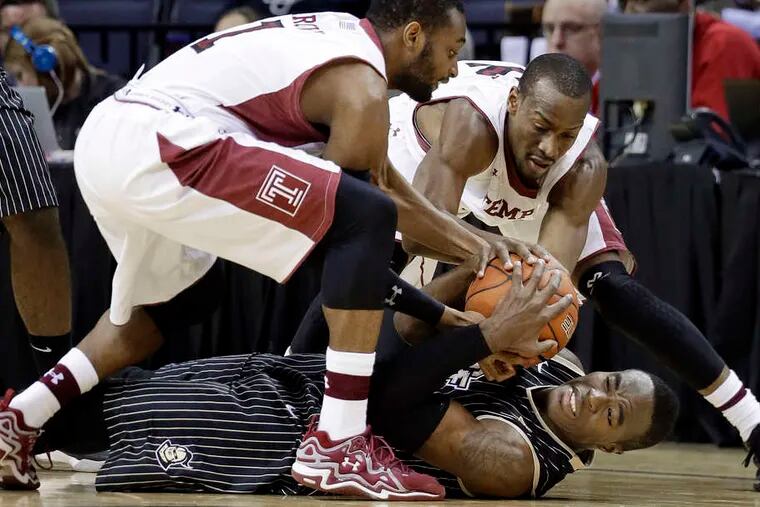 Central Florida guard Isaiah Sykes wrestles for the ball with Temple's Josh Brown (left) and Will Cummings in the first half in Memphis.