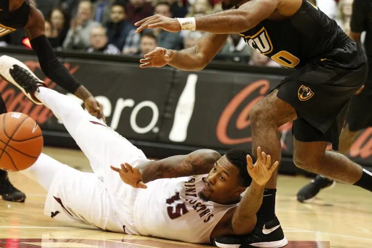 Isaiah Miles passes to an open teammate after winning a scramble for a loose ball in Tuesday's game against VCU. ( Charles Fox / Staff Photographer )