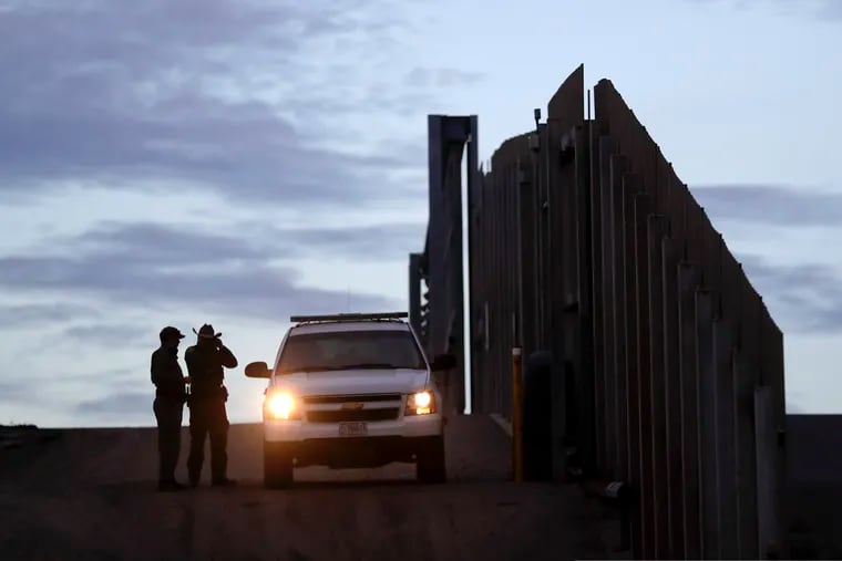 In this Nov. 21, 2018 photo, United States Border Patrol agents stand by a vehicle near one of the border walls separating Tijuana, Mexico and San Diego, in San Diego. As of this week, the ACLU has filed nearly 400 lawsuits and other legal actions against the Trump administration, some meeting with setbacks but many resulting in important victories. Of the lawsuits, 174 have dealt with immigrant rights.