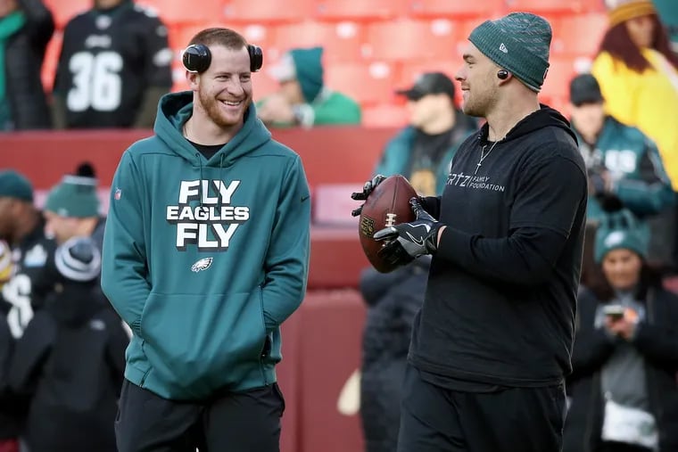 Injured Eagles quarterback Carson Wentz, left, talks with tight end Zach Ertz during warmups before a game against the Washington Redskins at FedEx Field in Landover, Md., on Sunday, Dec. 30, 2018.