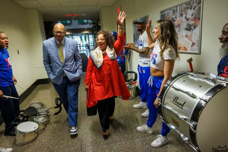 Catherine Hicks (in red), president of the Philadelphia branch of the NAACP, arrives for a news conference with Sam Staten Jr., business manager of Laborers' Local 332. The NAACP announced its support for the Sixers proposed Center City arena.