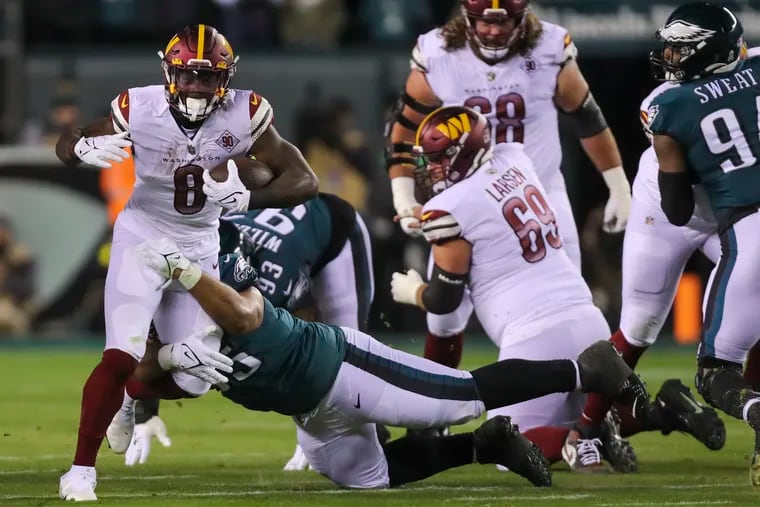 Washington  running back Brian Robinson gets stopped by  Eagles defensive tackle Marlon Tuipulotu during the first quarter Monday.