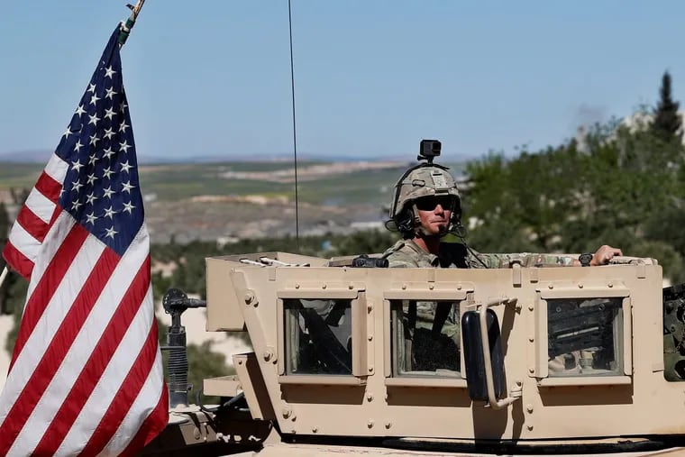 A U.S. soldier sits on his armored vehicle on a road leading a tense front line in north Syria earlier this month. President Donald Trump is considering retaliating against a suspected chemical attack led by Bashar Assad’s regime, but tweeted Thursday it might happen “not so soon at all.”