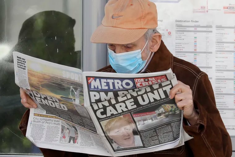 A man reads a newspaper with the headline: 'PM in intensive care', outside St Thomas' Hospital in central London as British Prime Minister Boris Johnson is in intensive care fighting the coronavirus.