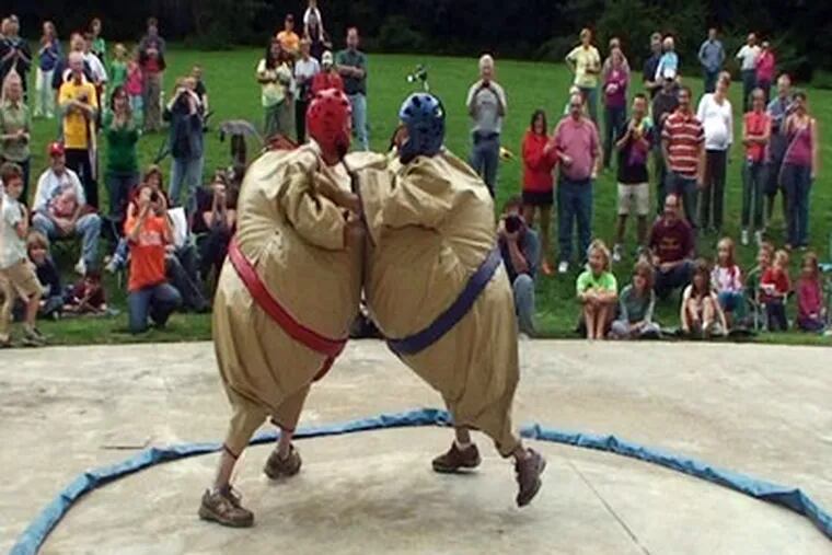 Republican Lansdale Mayor Andy Szekely (left) and Democratic challenger Ben Gross take out their political differences in a sumo-wrestling match while raising money for Manna on Main Street, a local charity. (Ron Tarver / Staff Photographer)