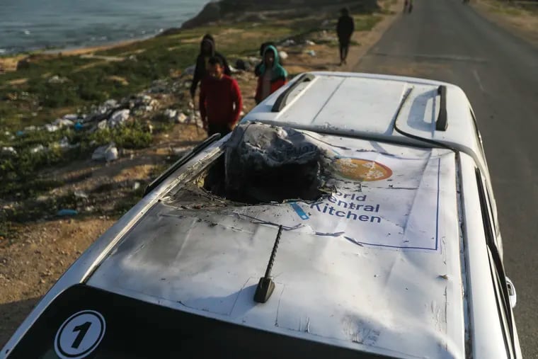 Palestinians inspect a vehicle with the logo of the World Central Kitchen wrecked by an Israeli airstrike in Deir al Balah, Gaza Strip, on Tuesday.