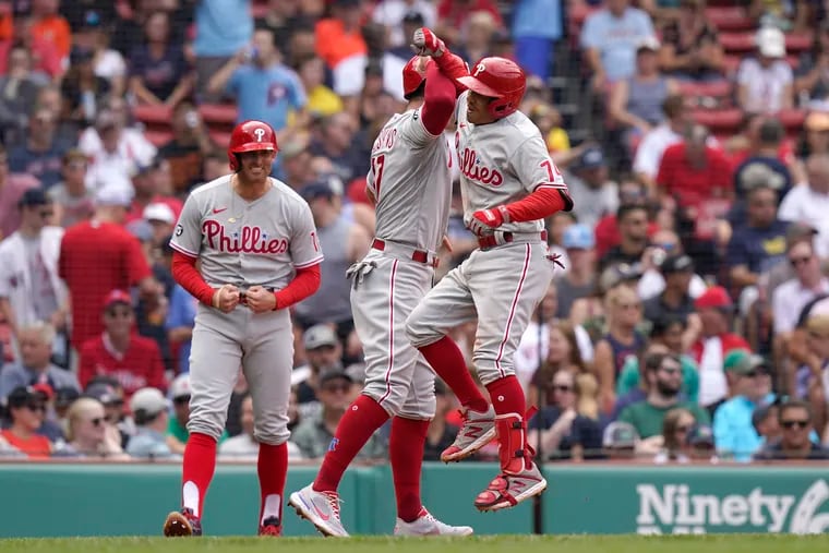 Philadelphia Phillies' Ronald Torreyes, right, celebrates his three-run home run with Rhys Hoskins, center, and Brad Miller, left, in the fourth inning of a baseball game against the Boston Red Sox, Sunday, July 11, 2021, in Boston. (AP Photo/Steven Senne)