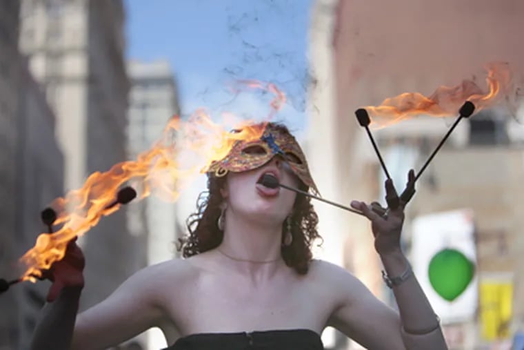 Mackenzia of Movement plays with fire on South Broad Street during the last day of the Philadelphia International Festival of the Arts. (David Swanson / Staff Photographer)