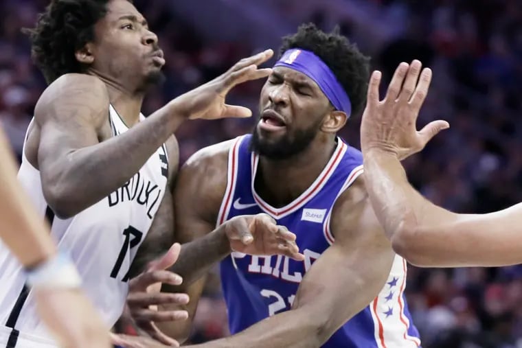 Sixers Joel Embiid losses the ball while being fouled by Brooklyn Nets Ed Davis on Thursday.
