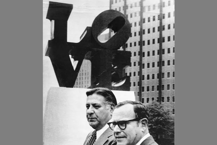Mayor Frank Rizzo and F. Eugene Dixon Jr., right, stand in rain beside the LOVE sculpture after is was permanently reinstalled at JFK Plaza in 1978.