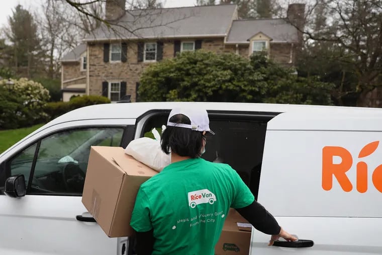 Driver Emir Lin carries an order of groceries and food from the Chinatown restaurant EMei to drop off for customer Nora Zhou at her home in Wynnewood, Pa., on Wednesday, March 31, 2021. RiceVan is a startup that delivers restaurant food and groceries — mostly from Chinatown businesses — to homes beyond the radius of typical delivery services, including as far as Delaware, New Jersey, and the Lehigh Valley.