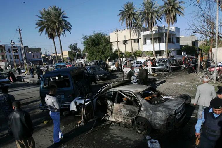 Iraqis stand at the site of a car bombing in the northern Baghdad Shiite neighborhood of Kazimiyah. The U.S. military said 20 were killed and 25 wounded in the blast.