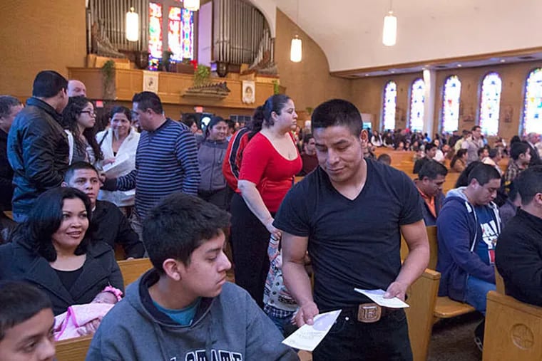A volunteer hands out brochures at Our Lady of Guadalupe encouraging cooperation with the police in solving crimes. Victims have been reluctant to come forward for fear of attention that could lead to deportation.  ED HILLE / Staff Photographer