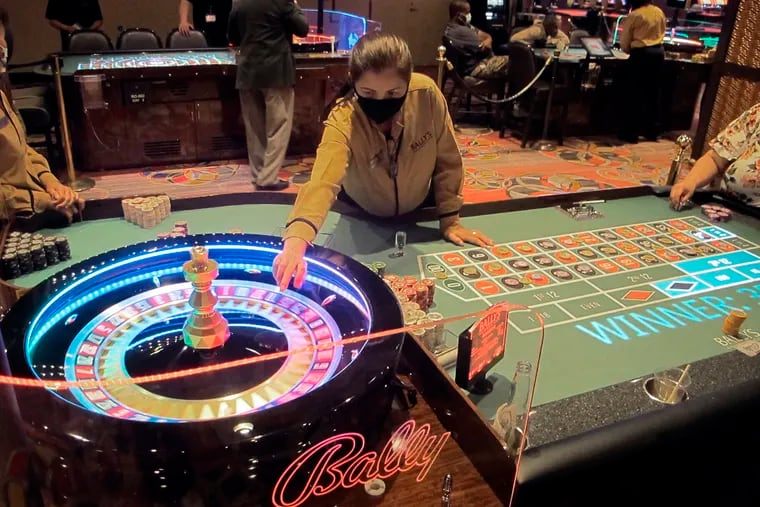This June 23, 2021 photo shows a dealer conducting a game of roulette at Bally's casino in Atlantic City, N.J. Rhode Island-based Bally's Corp. is spending $100 million on renovations to the property, which ranks last among Atlantic City's nine casinos in terms of gambling revenue. (AP Photo/Wayne Parry)