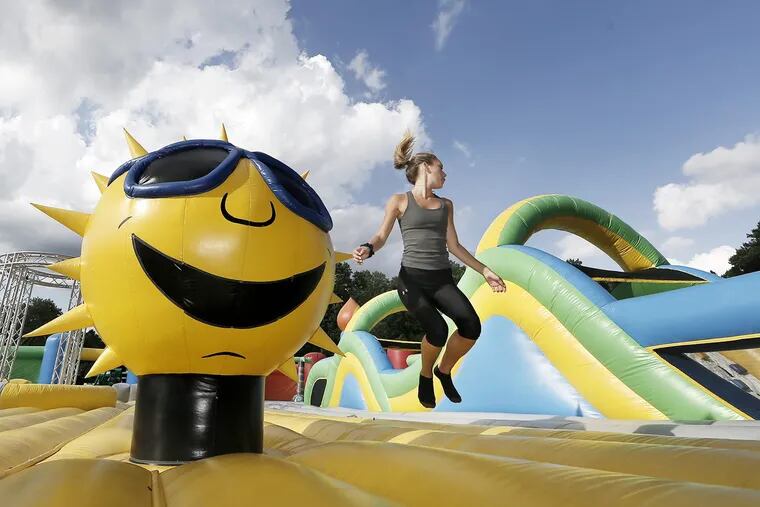 Claire Wolters jumps up with the sun in the Big Bouncer at the Big Bounce America The World's Biggest Bounce House  in Chester, Pa. on July 5, 2018.