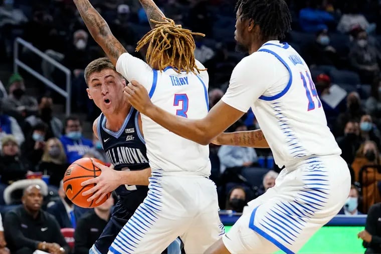 Villanova guard Collin Gillespie, left, looks to pass against DePaul's Jalen Terry, center, and Nick Ongenda during the first half of Saturday's Big East contest.