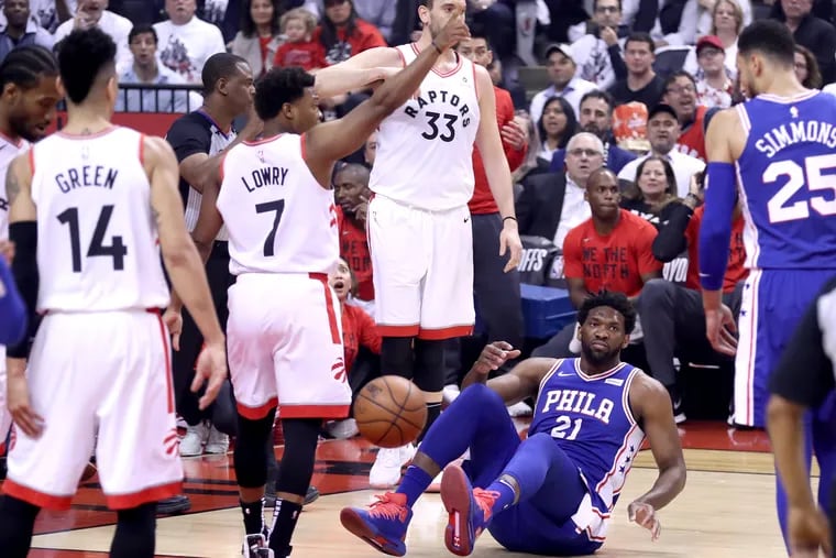 Joel Embiid lands on the floor after getting fouled by Marc Gasol of the Raptors on Tuesday.