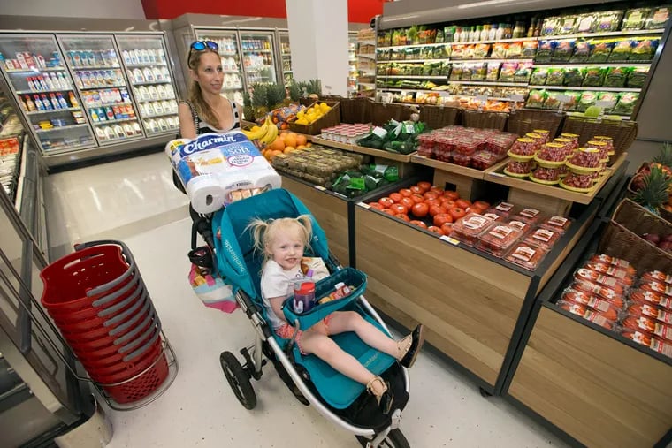 Darci Yusk and her daughter Blake, 3, make their way through the market section of the Target to pick up some groceries. The “flexible-format” version of the retailer opened Wednesday in the 1100 block of Chestnut Street.