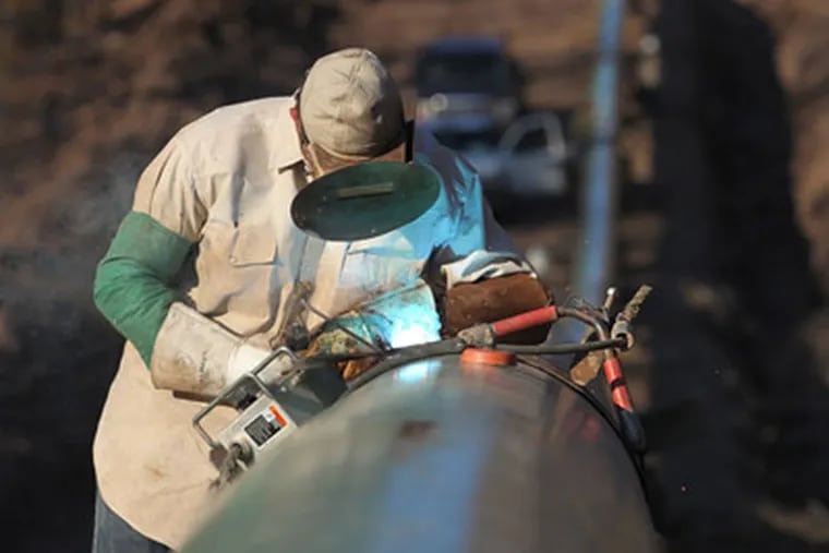 Randall Hill, welder for Appalachian Pipeline Construction, finishes off his top weld to a gathering pipe on the Springville Line gas pipeline.  (Michael Bryant / Staff Photographer)
