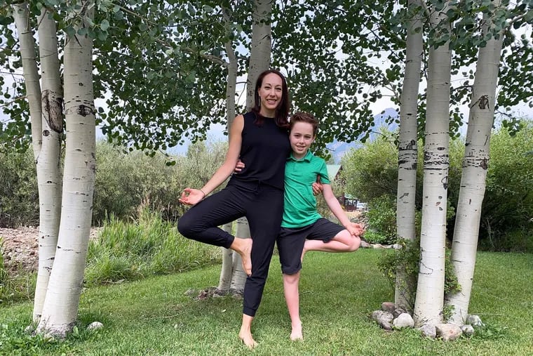 Dahvia Dalton, left, and her nine-year-old son, Beckett, stand side by side while holding tree pose.