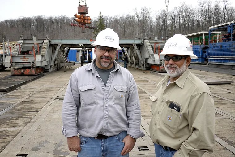 Wesley Sammons (left), a drilling supervisor for Seneca Resources Corp., and his boss Gus Trejo, drilling superintendent, stand in front of a drill rig assembly as a blowout preventer is lowered into place atop a Marcellus Shale natural gas well in Elk County, Pa.
