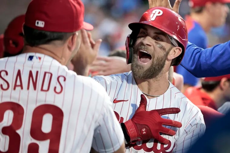 Bryce Harper celebrates his home run with Donny Sands in the third inning on Saturday at Citizens Bank Park.