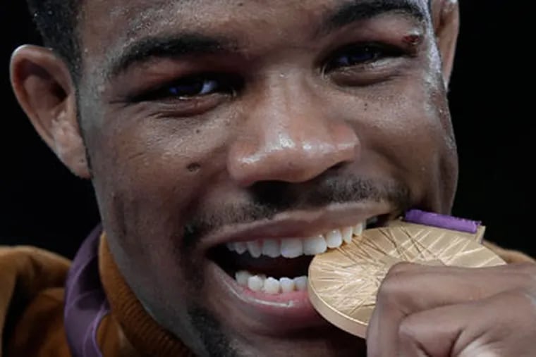U.S. wrestler Jordan Burroughs bites his gold medal after
winning the men's 74-kg freestyle wrestling competition. (Paul Sancya/AP)