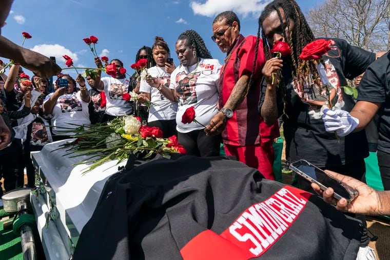 Devin Weedon's family, Nyah Burnside, sister, (fourth from right) Wytina Burnside-Weedon, mother, Gary Weedon, father, and Gary Burnside, brother, hold roses before placing them on his casket. Devin, 15, was fatally shot last week during an attempted robbery on his way to school.