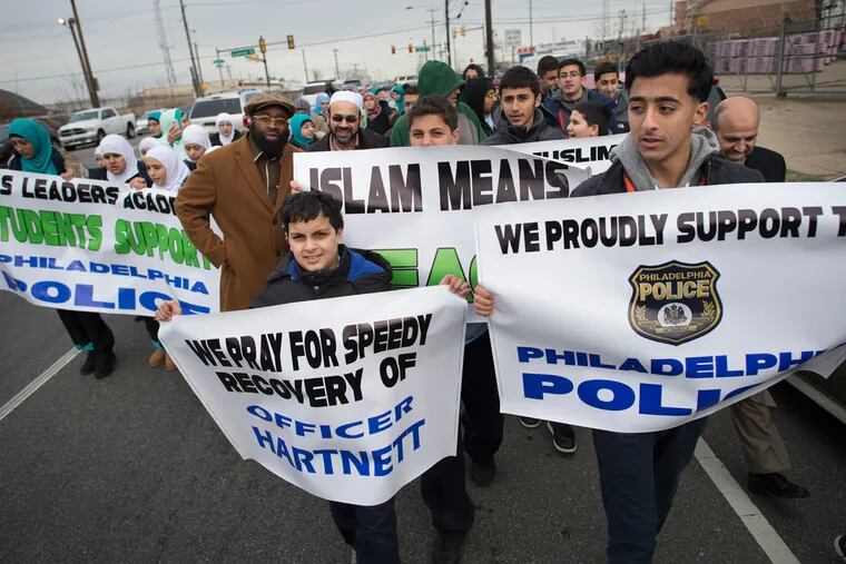 Jawad Salem, center, 12, and Ali Mohammad, right, 16, march with other students and members from the Muslim American Society of Philadelphia in support of the Philadelphia Police through the Hunting Park neighborhood on Tuesday, Jan. 12, 2016.