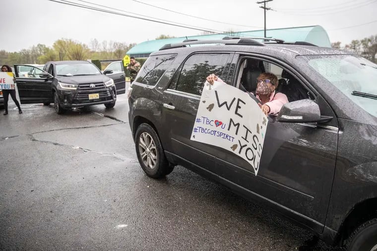 Alisa Burgess, part of Tabernacle Baptist Church's convoy, leans out of her passenger window to hold a We Miss You sign for the Conaway family , two of the older congregants of the Tabernacle Baptist Church who are sheltering at home and cannot go out, on April 26, 2020.