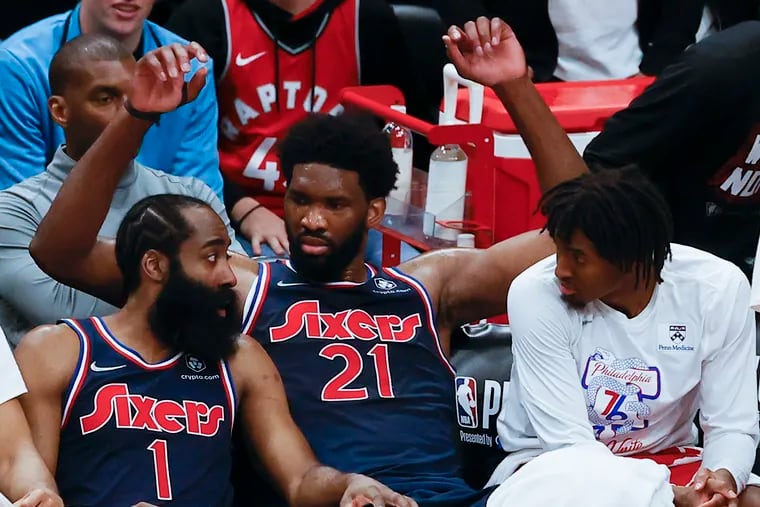 Injured Sixers center Joel Embiid needs help from James Harden, left, and Tyrese Maxey, left.