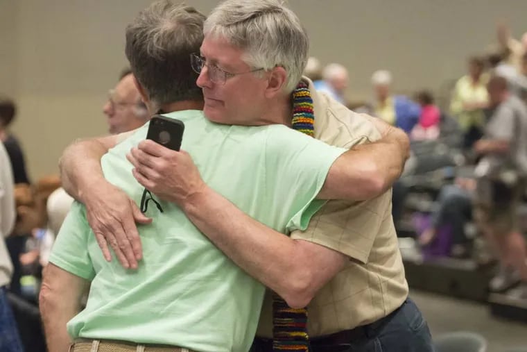 FILE - In this June 19, 2014, file photo, Gary Lyon, left, of Leechburg, Pa., and Bill Samford, of Hawley, Pa., celebrate after a vote allowing Presbyterian pastors discretion in marrying same-sex couples at the 221st General Assembly of the Presbyterian Church at Cobo Hall, in Detroit. The Presbyterian Church (U.S.A.) approved redefining marriage in the church constitution Tuesday, March 17, 2015, to include a "commitment between two people," becoming the largest Protestant group to formally recognize gay marriage as Christian and allow same-sex weddings in every congregation. (AP Photo/Detroit News, David Guralnick, File)