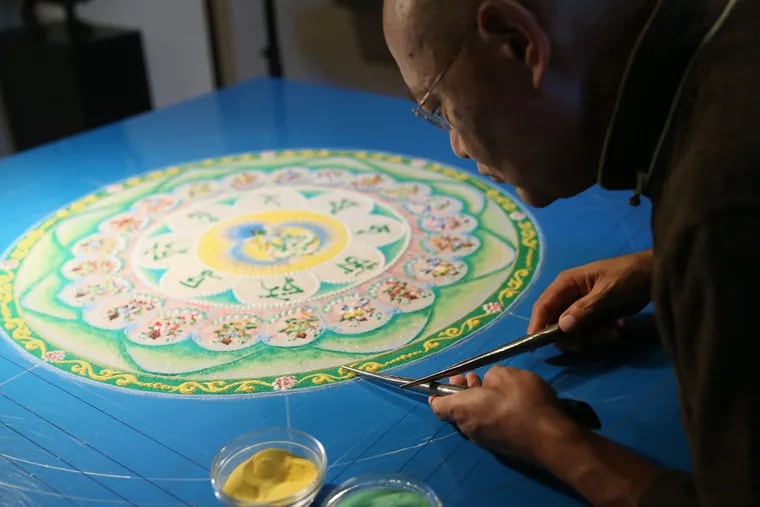 Spiritual director Losang Samten uses tools called chak-pur to create a sand mandala depicting the Green Tara, a beloved Buddhist diety, at the Chenrezig Tibetan Buddhist Center of Philadelphia.   The mandala, which symbolizes healing and protection, will be completed at the end of the week and then will be dismantled during a ceremony Sunday.