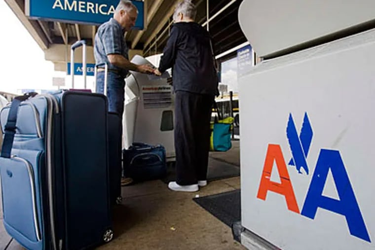 Travelers check luggage outside the American Airlines terminal at Phila. Airport. Joining US Airways would quicken nonstop flights to Asia. (AP file photo)