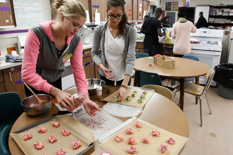 Bibiana Weber,R, and Phaedra Badawika work on cookies. Students at Woodbury High make cookies for the troops — in this case, alums of the school on Monday, December 9  2013.  (RON CORTES/Staff Photographer)