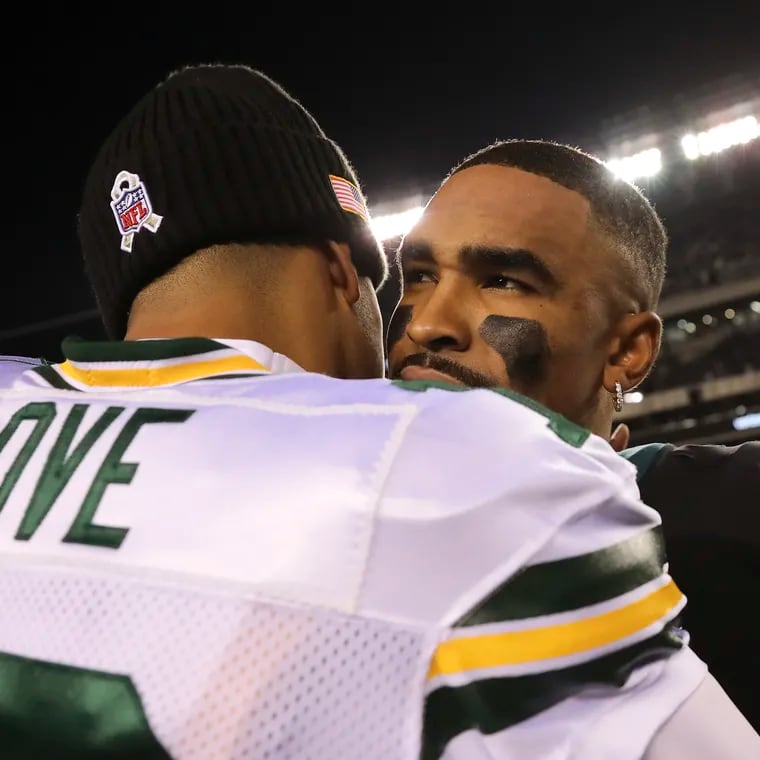 Eagles quarterback Jalen Hurts meets with Green Bay quarterback Jordan Love after a 40-33 win against the Packers on Nov.  27, 2022.