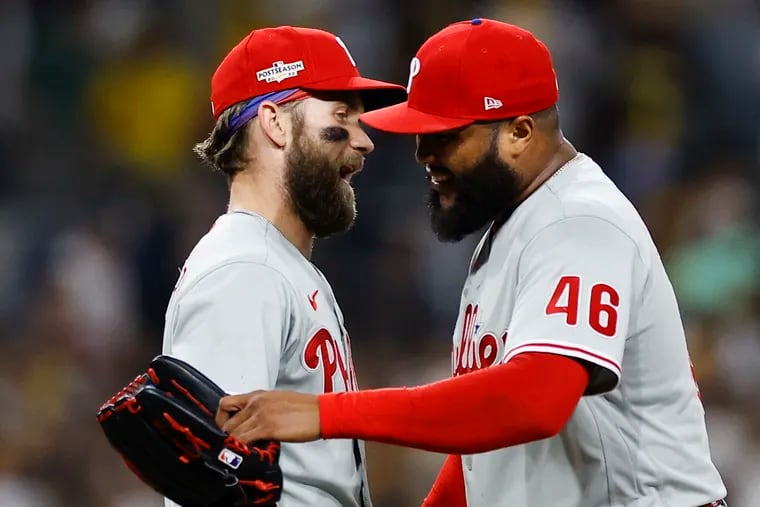 Phillies pitcher Jose Alvarado and designated hitter Bryce Harper share a laugh after their 2-0 win over the Padres in Game 1 of the NLCS.